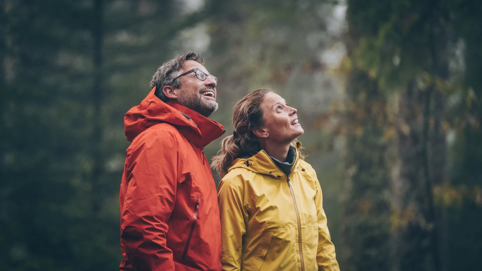 An older couple outdoors, smiling and listening to the sounds around them